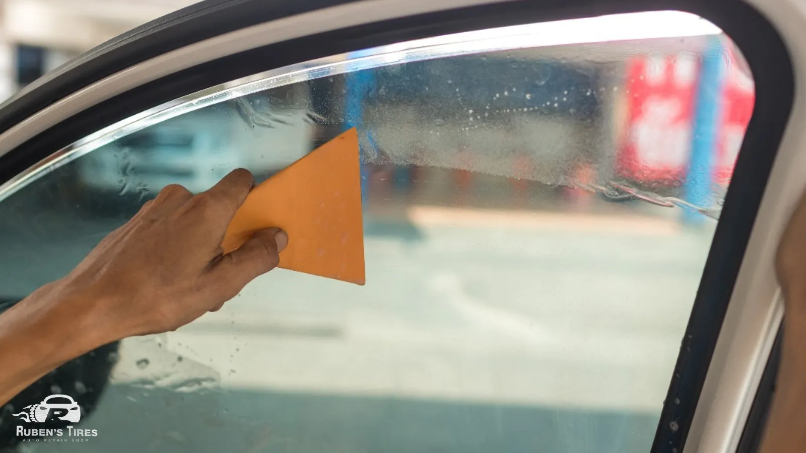 Rear window tint application with a tool for a smooth finish in South Semoran.