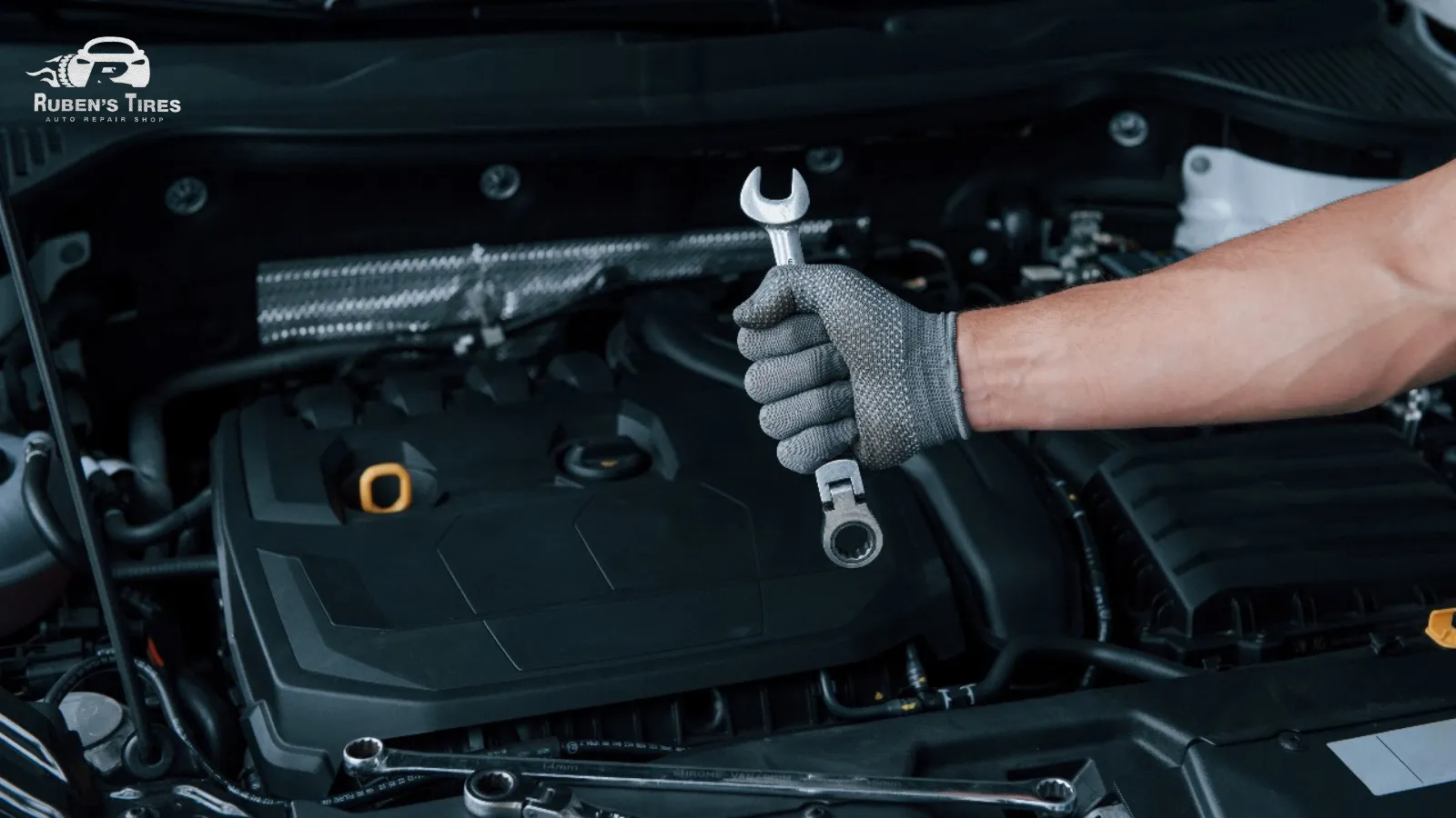 A mechanic holding a wrench while performing engine repairs at Ruben's Tires in South Semoran.