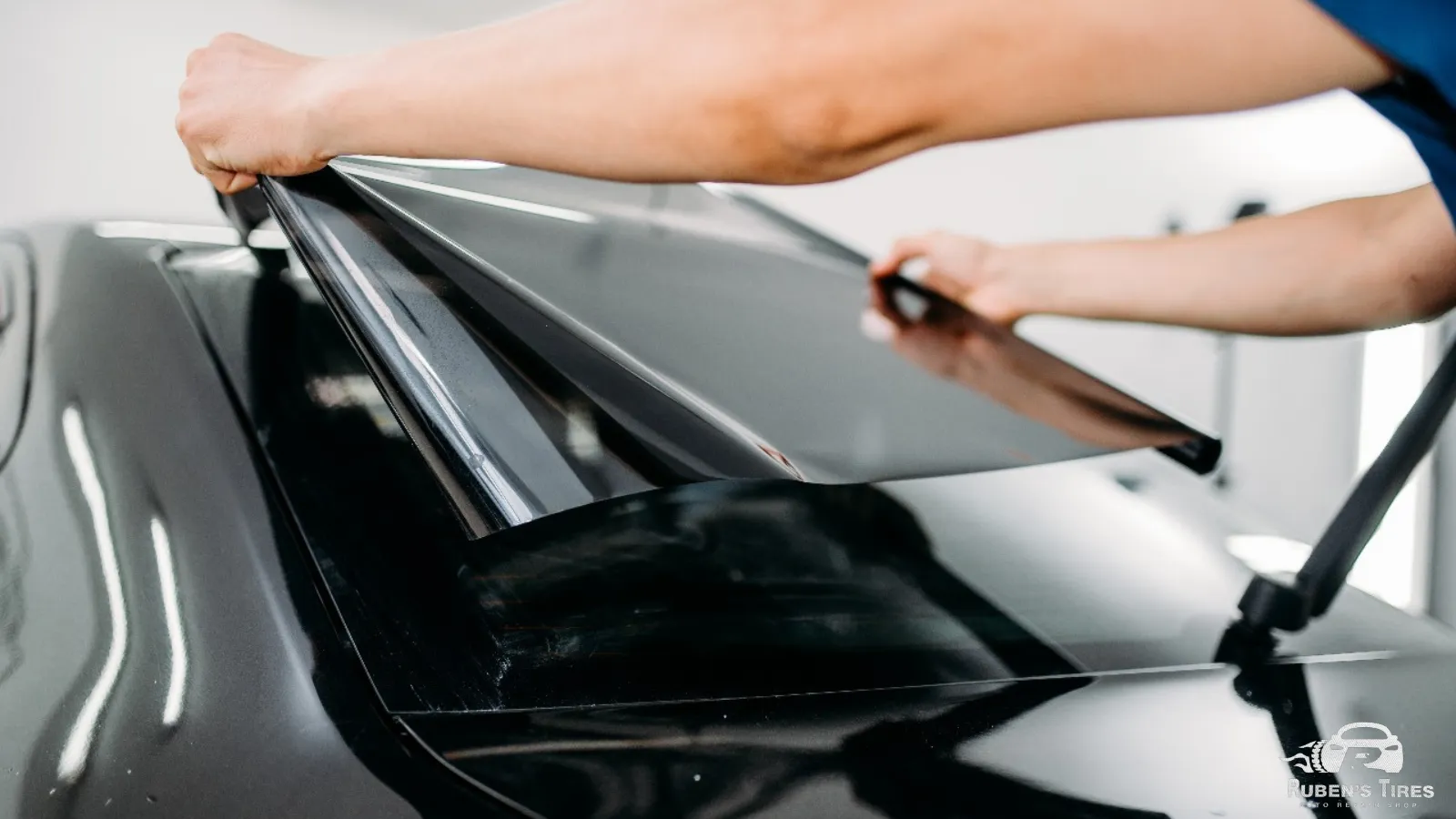 Close-up of hands applying window tint film on a car in South Semoran.